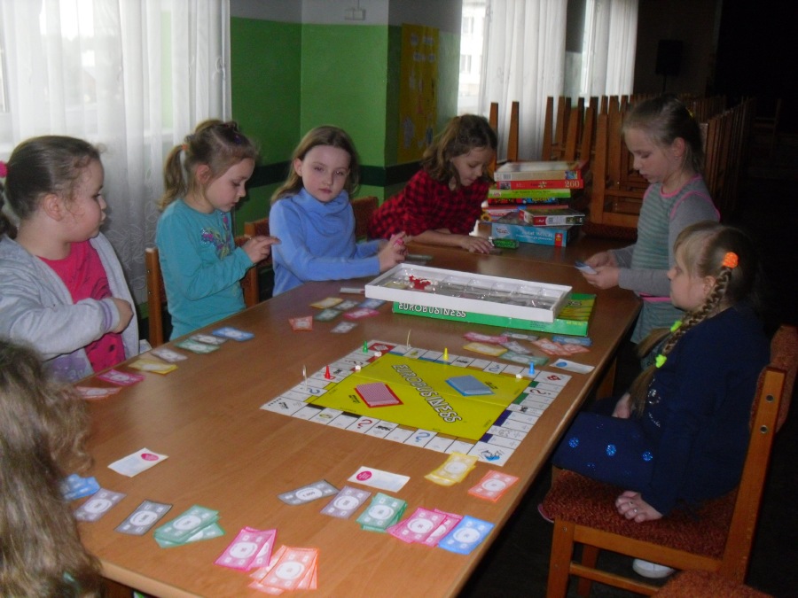 Dzieci przy stole z rozłożoną grą planszową