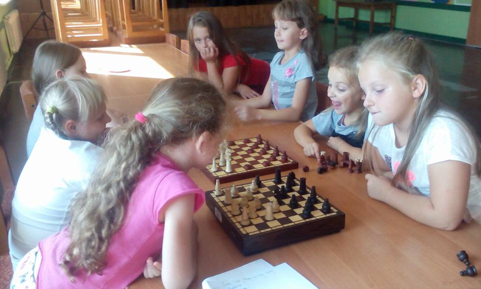 Dzieci grające przy stole w szachy
