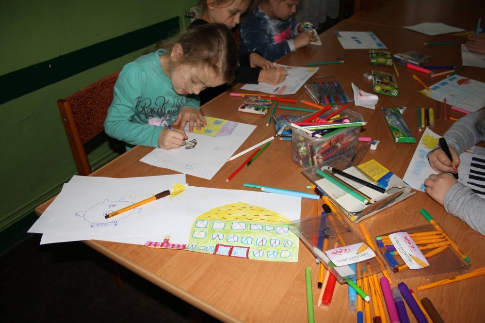 Dzieci podczas prac artystycznych, przybory porozkładane na stole